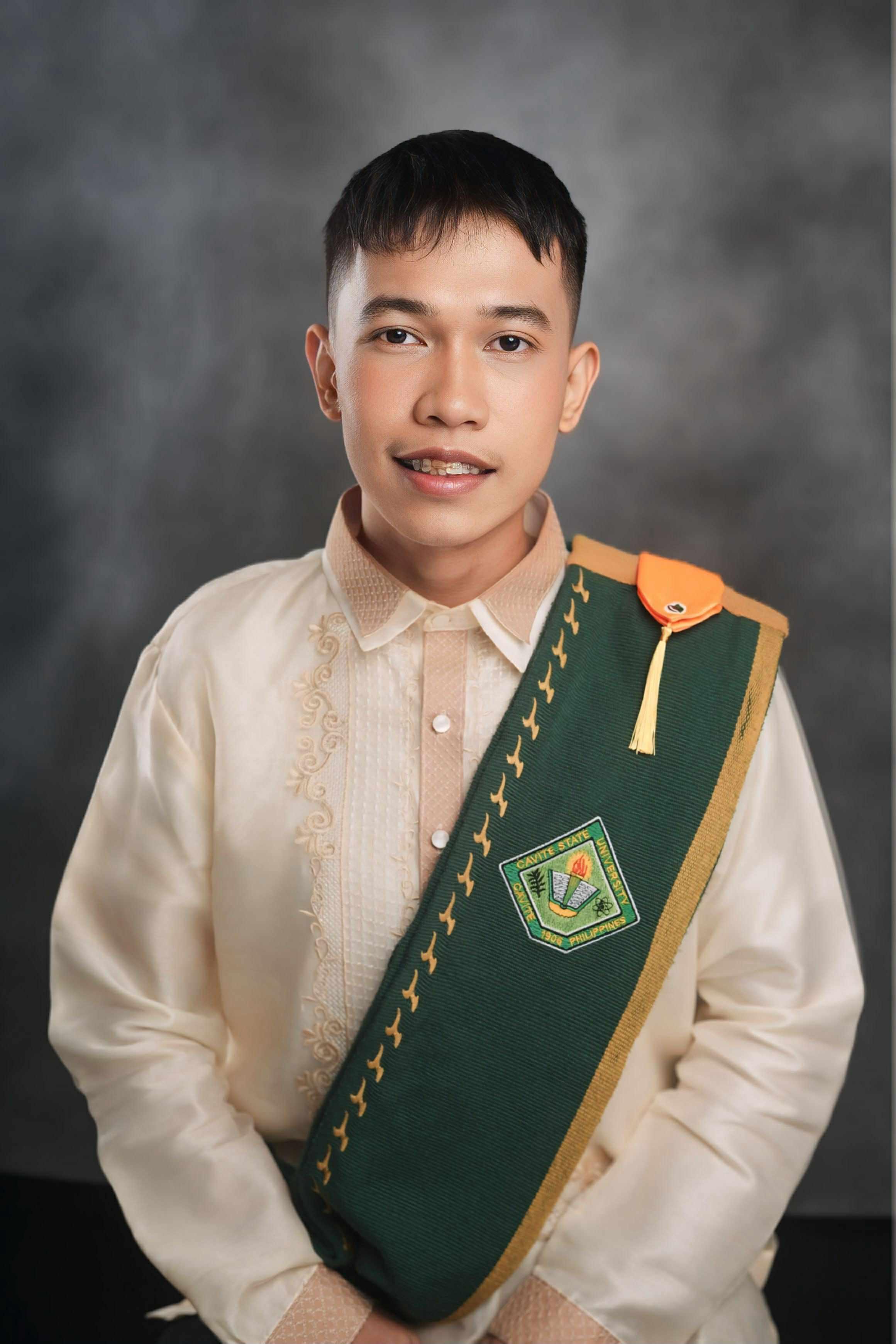 A picture of Darenz Jasper A. Hicap, dressed in a white barong, smiling at the camera with arms crossed.